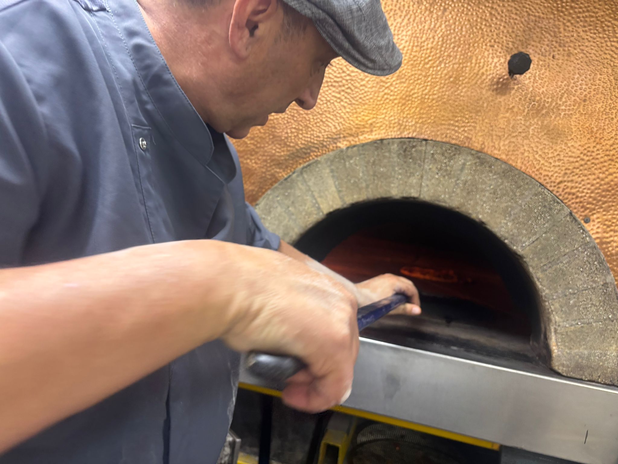 Mimmo maestro pizzero napolitano trabajando en el horno de leña